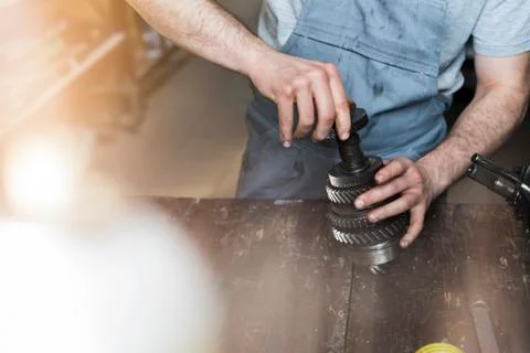 Mechanic assembling car part in auto repair shop Stock Photos