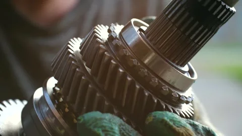 Mechanic assembling gearbox shaft in car repair shop Stock Footage 317905253