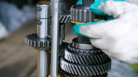 Mechanic assembling a manual car gearbox transmission system Stock Footage 321739261