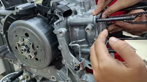 Mechanic Assembling Motorcycle Engine and Educational Cutaway Model Stock Footage 320386031