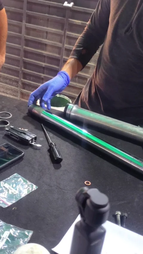 Mechanic assembling motorcycle fork tube, workshop table closeup, vertical Stock Footage 325782672