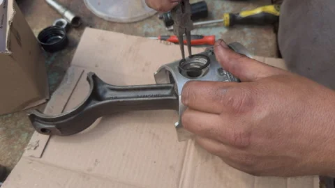 Mechanic assembling piston and connecting rod of car engine Stock Footage 338410982