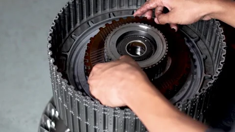 Mechanic assembling transmission friction plate into clutch drum. Stock Footage 344026110