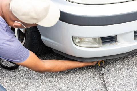 Mechanic attach cable onto broken down car to be towed onto tow truck Stock Photos