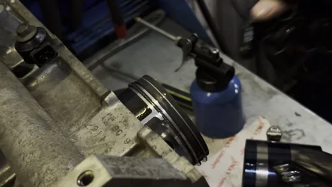 Mechanic in black gloves installing metal ring into engine block. Video stock 332064920