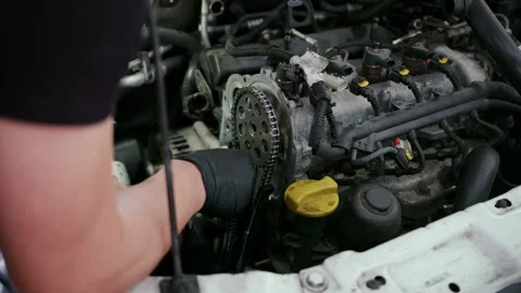 Mechanic with black gloves working on car engine in auto repair shop Stock Footage 340875646