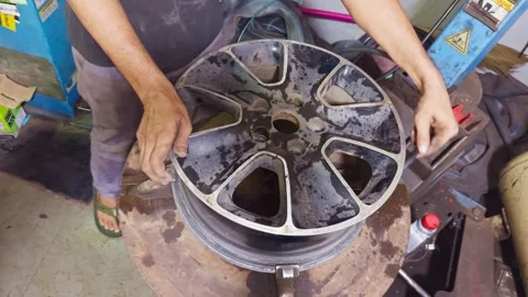 Mechanic blows dust off wheel using compressed air Stock Footage 311620665