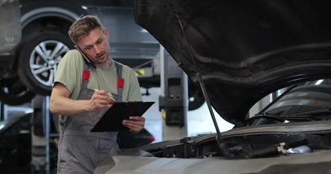 Mechanic calls customers for communication, in the car service center. Stock Footage 341865519