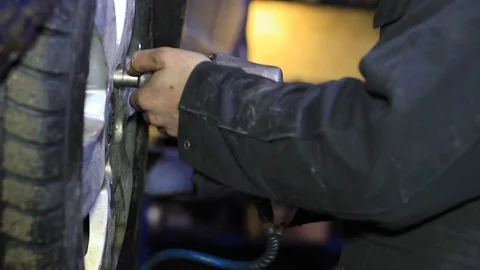 Mechanic for car checking brake system in a car at garage Stock Footage 103543899