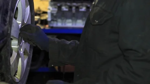 Mechanic for car checking brake system in a car at garage Stock Footage 103858530