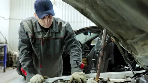 Mechanic carefully diagnosing vehicle engine problems, working with precision Stock Footage 338217661