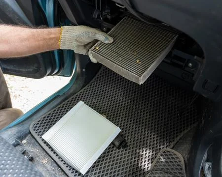 A mechanic changes the cabin air filter of a car. Stock Photos