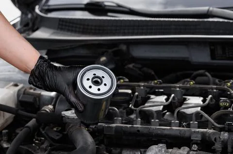 Mechanic changes filter. Mechanic professionally works on fuel filter during Stock Photos