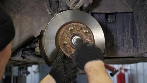 The mechanic changes the front brake pads when repairing the car. Stock Footage 340245354