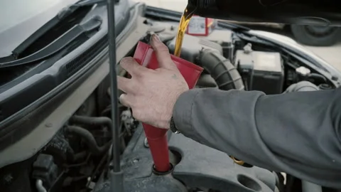 The mechanic changes the oil in the engine of the car Stock Footage 86456275