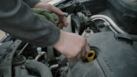 The mechanic changes the oil in the engine of the car Stock Footage 86457046