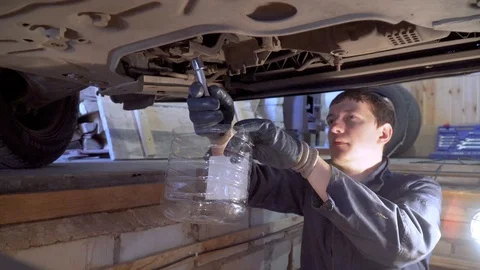 mechanic changes the oil in the gearbox | Stock Video | Pond5