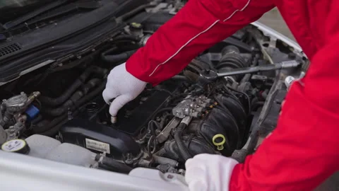 Mechanic changes spark plugs in a car engine. Installs a new iridium spark plug Stock Footage 260617355
