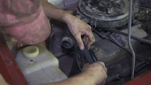 Mechanic changes a timing belts and an alternator Stock Footage 110863831
