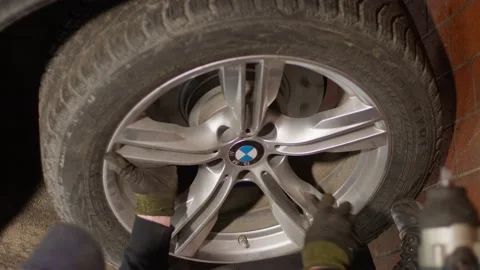 A mechanic changes a tire on a BMW X5 car Stock-Footage 233536446