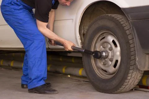 Mechanic changes the wheel of the car Stock Photos