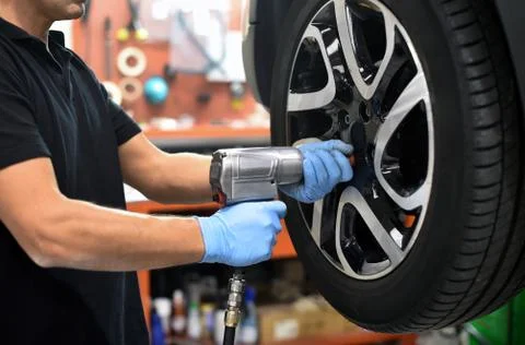 Mechanic changing a car tire in a workshop Stock Photos