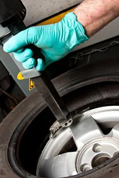 Mechanic changing car wheel in auto repair shop Stock Photos