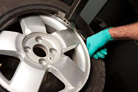 Mechanic changing car wheel in auto repair shop Stock Photos
