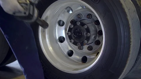 Mechanic is changing truck tire in the autorepair service center. Mechanic is Stock Footage