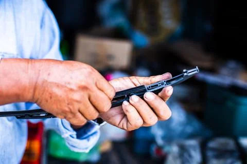 The mechanic is changing the windshield wiper rubber. Stock Photos