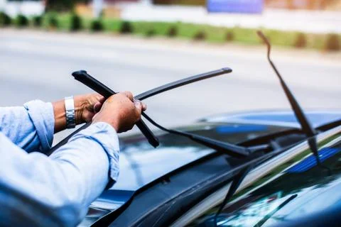 The mechanic is changing the windshield wiper rubber. Stock Photos