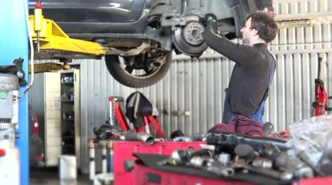 Mechanic checking car brake system in a workshop Stock Footage 68591304