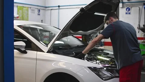 Mechanic checking a car engine and looking with a flashlight in a workshop 4 Video stock 132304037