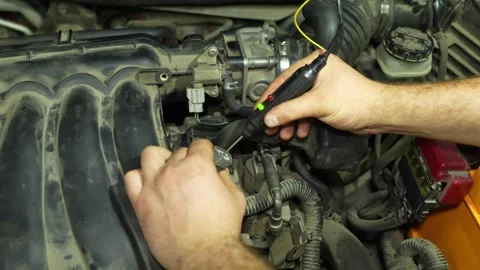 Mechanic checking car engine electrical connector with a digital probe teste Stock Footage 340335012