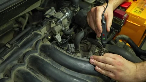Mechanic checking car engine electrical connector with a digital probe teste Stock Footage 340335063