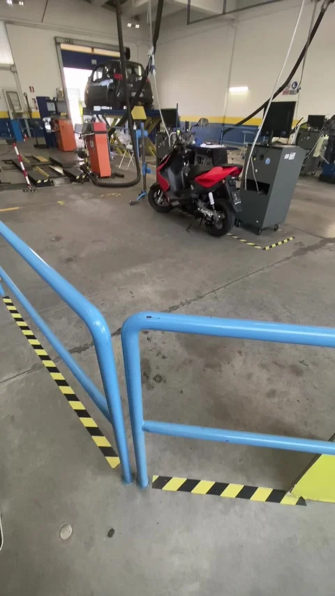 Mechanic checking emissions of car and scooter in a garage 스톡 동영상 303055484