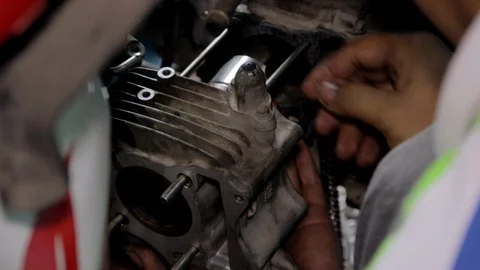 Mechanic checking motor casing whilst on rods near engine on motorbike. Vídeos de archivo 120205533