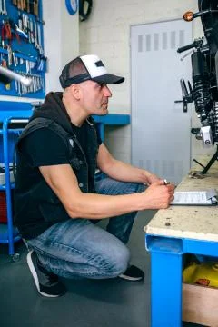 Mechanic checking motorcycle Stock Photos