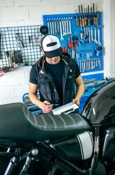 Mechanic checking motorcycle Stock Photos