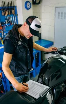 Mechanic checking motorcycle Stock Photos