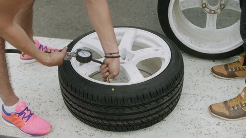 Mechanic checking pressure in a new, just assembled wheel with a car pump Stock-Footage 129510739