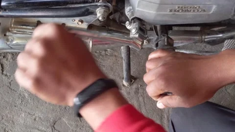 Mechanic checking starting problem in Hero Honda motorcycle at workshop. Stock Footage 229302628