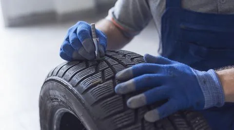 Mechanic checking tire tread depth and wear Stock Photos