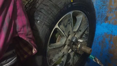 Mechanic checks rim alignment using balancing machine Stock Footage 311620799