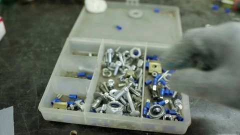 Mechanic choosing bolts from box of assorted parts Vídeos de archivo 128921723