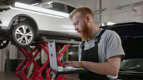 Mechanic in a clean uniform checks the electrical systems of a car Stock Footage 212062956