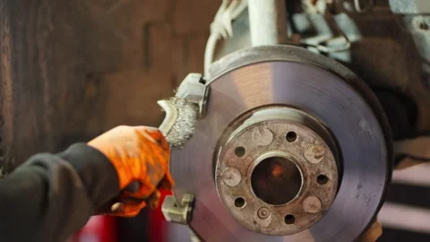 Mechanic Cleaning Brake Disc with Wire Brush Close Up Stock Footage 331675320