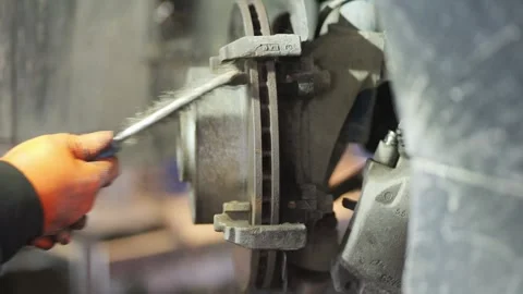 Mechanic Cleaning Brake Disc with Wire Brush Close Up Stock Footage 331675367