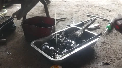 A mechanic is cleaning dirty motorcycle engine parts. Stock Footage 324942081