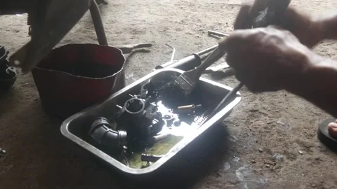 A mechanic is cleaning dirty motorcycle engine parts. Video stock 324942127